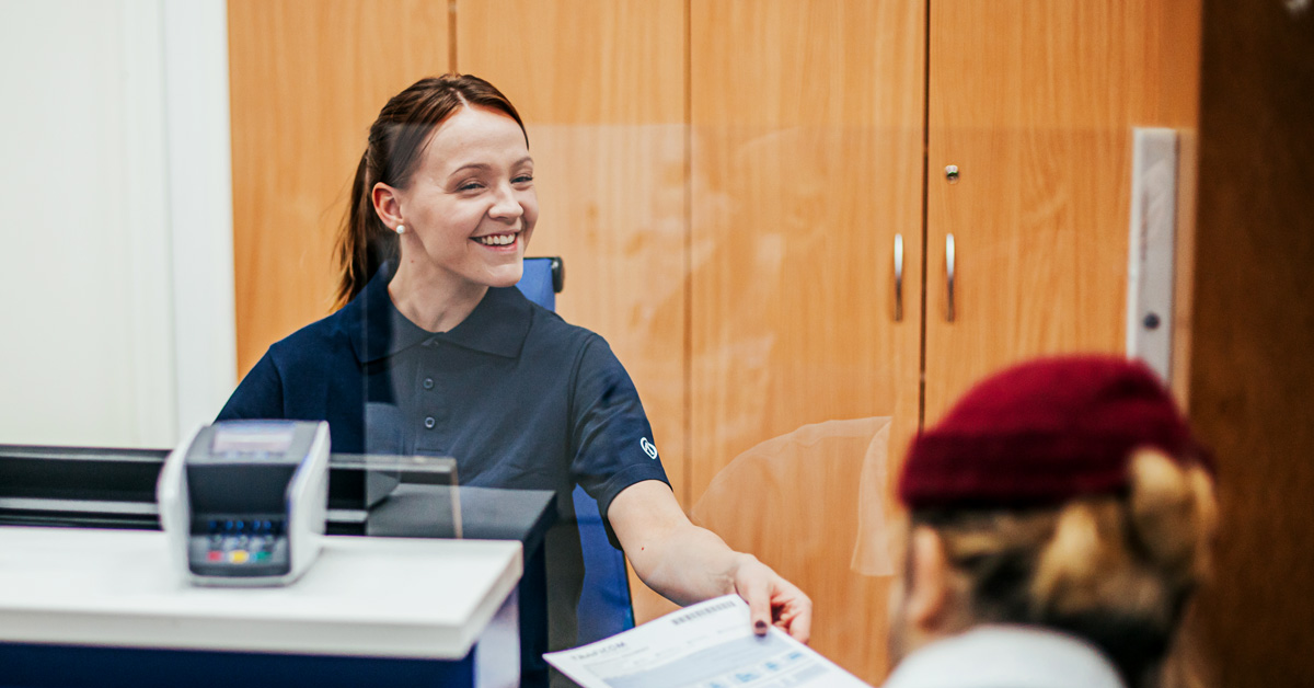 A customer handing some forms to the service advisor.