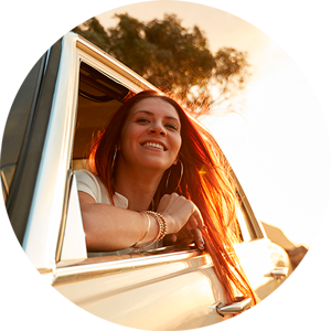 A woman is peeking out of the car window.